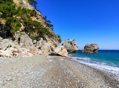 Türkiye 'deki Akdeniz manzarası, Beldibi köyündeki kayalar, dağlar, çam ağaçları ve çiçekler