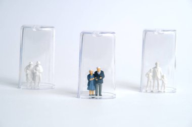 Pandemik korona virüsü kavramsal minyatür insanlar sosyal uzaklık stratejisini fotoğraflıyorlar. Tüp izolasyonunda orta yaşlı bir figür. Resim Fotoğrafı