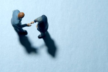 İki iş adamının üst düzey görüşü, el sıkışma ortaklığı anlaşması yapıyor. Minyatür insanlar kavramsal fotoğrafçılığı şekillendirir