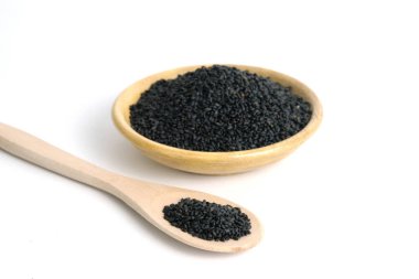 Tahta kasede ve kaşıkta tatlı fesleğen tohumları, beyaz arka planda izole edilmiş, stüdyo ışıklandırmalı.