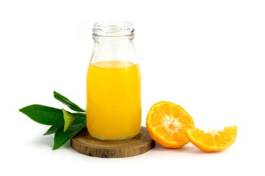 Ahşap altlığın üstünde taze portakal suyu, çiğ, dilimlenmiş portakal meyvesi, beyaz arka planda stüdyo ışıklandırmasıyla izole edilmiş.