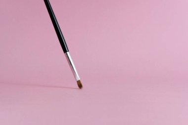 Pembe pastel arka planlı ön manzara fırça makyaj aletleri. Resim fotoğrafı.