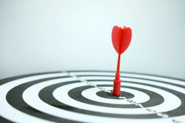 Gri zemin üzerinde kırmızı ok olan tahta dart tahtası