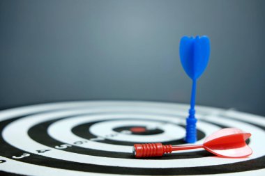 Koyu arkaplan üzerinde kırmızı mavi ok olan tahta dart tahtası