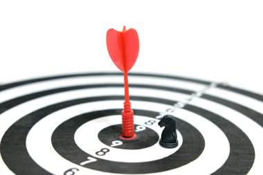 Başarı ve zaferin kavramsal resmi - kırmızı ok hedef tahtanın tam ortasına saplanmış satranç atı taşıyla