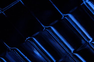 Soyut makro fotoğrafçılık. Cam lamba dokusunda açık mavi ışık. Bulanık arkaplan