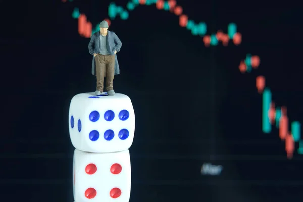 Miniature tiny people toys photography. People standing above dice, investing in stock market without analyzing the market