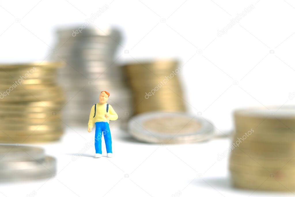 School admission budget.  A kid, standing between coin money stack. Miniature tiny people toys photography. isolated on white background.