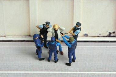 Polis ve askeri güvenlik görevlisi tarafından tutuklanan bir erkek ya da çocuğun minyatür insanları. resim fotoğrafı