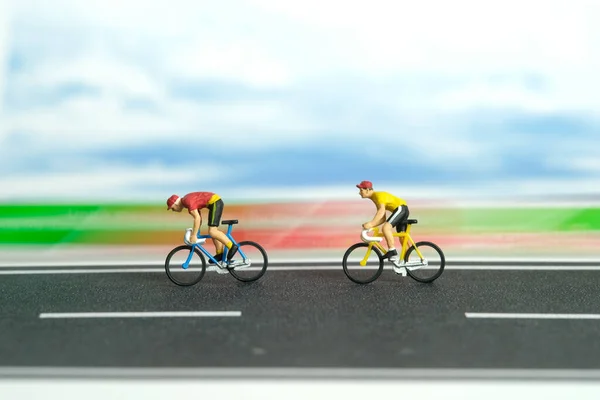 Miniature people toy figure photography. Fast movement motion bicycle. A biker cycling on a track with fast speed. Image photo