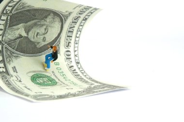 Minyatür insanlar oyuncak fotoğrafçılık. Kaykay ödül kazanma konsepti. Genç bir kaykaycı, beyaz arka planda soyutlanmış para kağıtlarının üzerinde. Resim fotoğrafı.