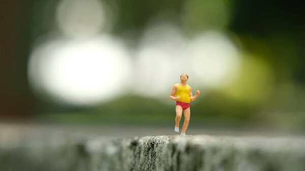 Миниатюрные люди игрушечные фигурки фотографии. Сольная пробежка. Толстяки бегают по парку на открытой трассе. Фото изображения