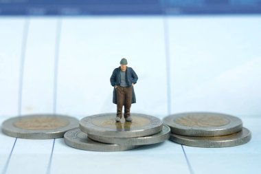 Minyatür insanlar oyuncak fotoğrafçılık. İflas kavramları. Parası olmayan üzgün bir adam banka hesabından tasarruf defterinin üstünde duruyor. Beyaz arka planda izole edilmiş. Resim fotoğrafı.