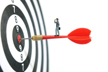 Minyatür minyatür insanlar fotoğraf çekmeyi sever. İş stratejisi çizimi. Dürbünlü teleskop kullanan bir iş adamı. Dart tahtasında kırmızı okun üzerinde duruyor. Beyaz arka planda izole edilmiş. Resim fotoğrafı.