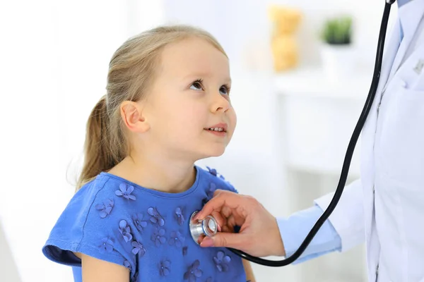 Lekarz badający małą dziewczynkę stetoskopem. Szczęśliwy, uśmiechnięty pacjent na zwykłej inspekcji medycznej. Medycyna i koncepcje opieki zdrowotnej — Zdjęcie stockowe