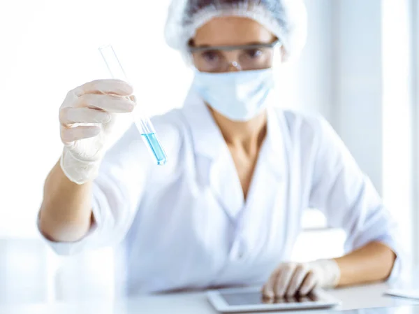 Cientista profissional em óculos de proteção pesquisando tubo com reagentes em laboratório. Conceitos de medicina e pesquisa científica — Fotografia de Stock