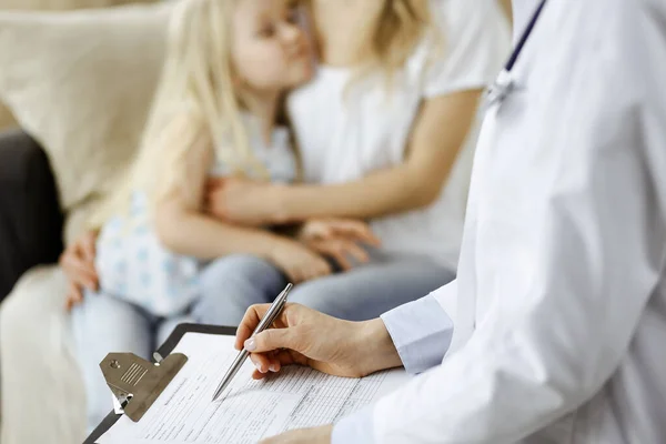 Dokter en patiënt. Kinderarts die klembord gebruikt terwijl ze het kleine meisje onderzoekt met haar moeder thuis. Ziek en ongelukkig kind bij medisch onderzoek. Geneesmiddelenconcept — Stockfoto