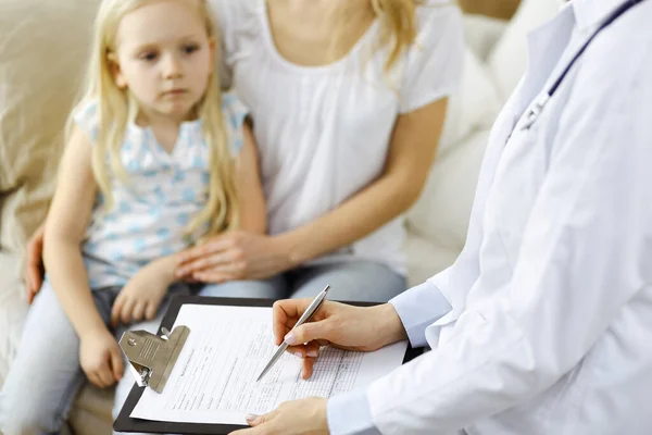 Dokter en patiënt. Kinderarts die klembord gebruikt terwijl ze het kleine meisje onderzoekt met haar moeder thuis. Ziek en ongelukkig kind bij medisch onderzoek. Geneesmiddelenconcept — Stockfoto