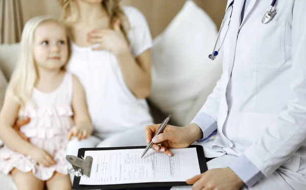 医者と患者だ。小児科医は、自宅で母親と一緒に小さな女の子を検討しながら、クリップボードを使用して.医学の試験で幸せなかわいい白人の子供。医学の概念 — ストック写真