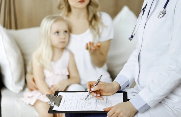 Dokter en patiënt. Kinderarts die klembord gebruikt terwijl ze het kleine meisje onderzoekt met haar moeder thuis. Ziek en ongelukkig kind bij medisch onderzoek. Geneesmiddelenconcept — Stockfoto