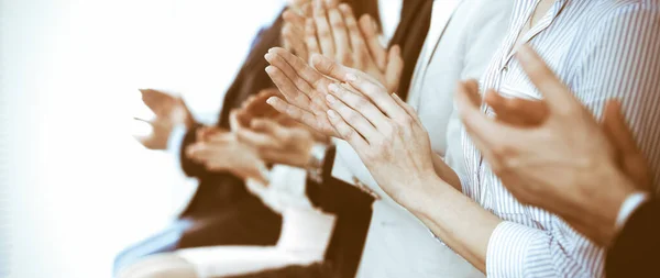Επιχειρηματίες χειροκροτούν και χειροκροτούν σε συνάντηση ή συνέδριο, κοντινό πλάνο των χεριών. Ομάδα αγνώστων επιχειρηματιών και γυναικών στο σύγχρονο λευκό γραφείο. Επιτυχής ομαδική εργασία ή εταιρική προπονητική έννοια — Φωτογραφία Αρχείου