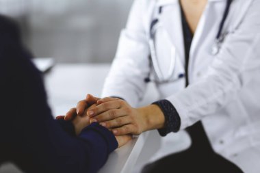 Bilinmeyen kadın doktor, kadın hastasına güvence veriyor, yakın plan. Doktor bir kadına danışmanlık yapıyor ve tavsiyelerde bulunuyor. Tıbbi ahlak ve güven kavramları. Tıpta empati