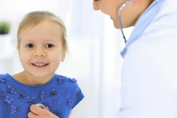 Medico che esamina una bambina dallo stetoscopio. Felice paziente bambino sorridente al solito controllo medico. Concetti di medicina e sanità — Foto Stock