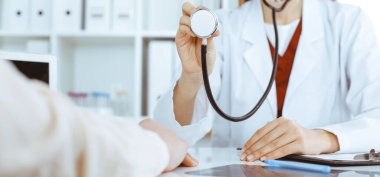 Elinde steteskop olan kimliği belirsiz bir kadın doktor. Doktor bir hastayı muayene etmeye hazır, yakın çekim. Tıp konsepti