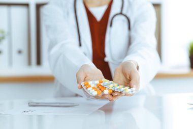 Bilinmeyen kadın doktor farklı tablet kabarcıkları sunuyor, yakın plan. Tıp konsepti