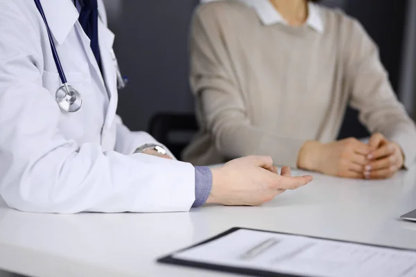 Médico desconhecido e paciente discutindo algo enquanto estava sentado na clínica. Melhor serviço médico no hospital, medicina, parada pandêmica — Fotografia de Stock