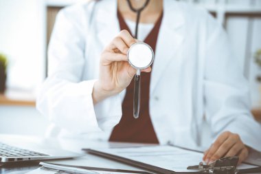 Elinde steteskop olan kimliği belirsiz bir kadın doktor. Doktor bir hastayı muayene etmeye hazır, yakın çekim. Tıp konsepti