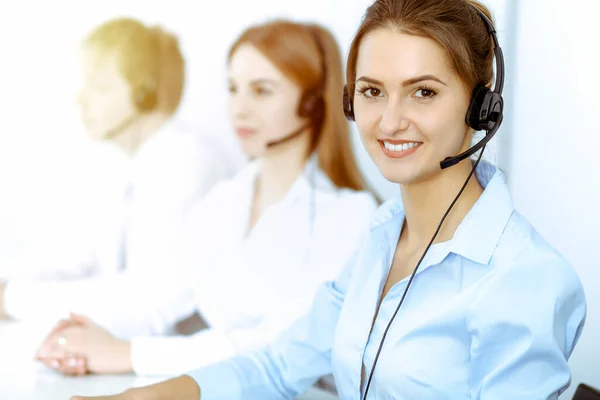 Call center. Focus on beautiful business woman in headset