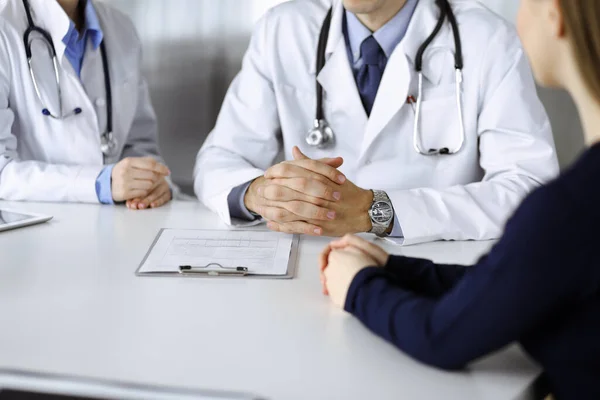 Médico desconhecido ouvindo sua paciente enquanto estava sentado na clínica moderna. Serviço médico perfeito, conceito de medicina durante a pandemia de Coronavirus. Covid 2019 — Fotografia de Stock