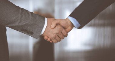 Ofisteki iş adamları ayakta ve el sıkışıyorlar, yakın plan. İş iletişimi kavramı. El sıkışma ve pazarlama