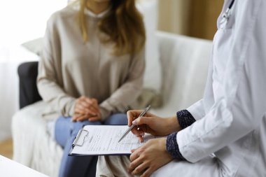 Bilinmeyen kadın doktor ve hasta içeride otururken sağlık muayenesini tartışıyorlar. Coronavirus salgını ve kendini izolasyon karantinası süresince evde kal