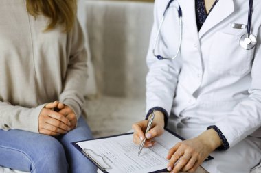 Bilinmeyen kadın doktor ve hasta içeride otururken sağlık muayenesini tartışıyorlar. Coronavirus salgını ve kendini izolasyon karantinası süresince evde kal