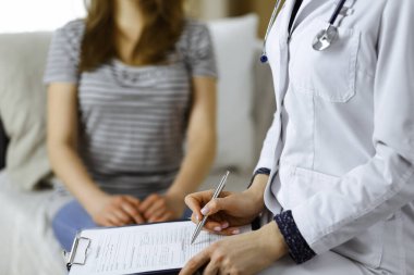 Bilinmeyen kadın doktor ve hasta sıcak oturma odasında otururken sağlık muayenesini tartışıyorlar. Coronavirus salgını ve kendini izolasyon karantinası süresince evde kal