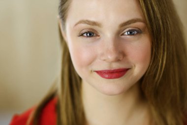 Zeki, kendinden emin, gülümseyen, Avrupalı bir kadının kollarını kavuşturup evinde dikilirken çekilmiş bir fotoğrafı. Çekici genç kız öğrenci serbest çalışan, kırmızı giyinmiş, kameraya bakıyor.