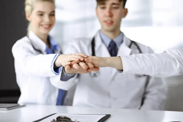 Gruppo di medici che si uniscono in cerchio e sono pronti ad aiutare i pazienti mentre sono seduti alla scrivania nel moderno ufficio ospedaliero. Lavoro di squadra di successo in medicina, Coronavirus contro concetto — Foto Stock