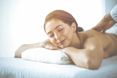 Güzel esmer kadın gözleri kapalı sırt masajından hoşlanıyor. Spa ve tıp konsepti