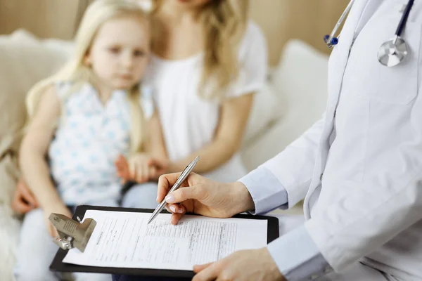 Dokter en patiënt. Kinderarts die klembord gebruikt terwijl ze het kleine meisje onderzoekt met haar moeder thuis. Ziek en ongelukkig kind bij medisch onderzoek. Geneesmiddelenconcept — Stockfoto