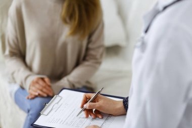 Bilinmeyen kadın doktor ve hasta içeride otururken sağlık muayenesini tartışıyorlar. Coronavirus salgını ve kendini izolasyon karantinası süresince evde kal