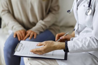 Bilinmeyen kadın doktor ve hasta içeride otururken sağlık muayenesini tartışıyorlar. Coronavirus salgını ve kendini izolasyon karantinası süresince evde kal