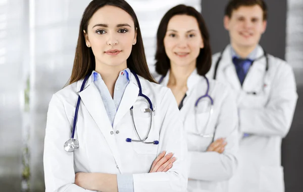 Gruppo di giovani medici professionisti è in piedi come una squadra con le braccia incrociate in uno studio ospedaliero ed è pronto ad aiutare i pazienti. Assistenza medica, assicurazione sanitaria, miglior trattamento delle malattie e — Foto Stock