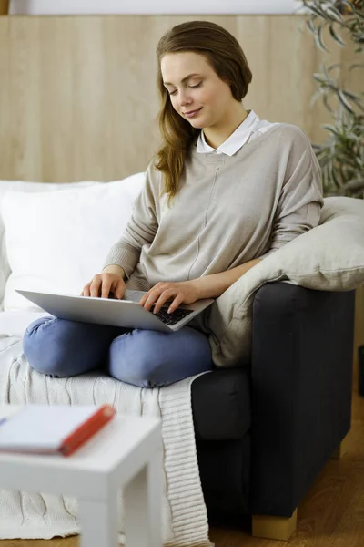 Mulher de negócios trabalhando no computador portátil sentado dentro de casa durante a quarentena Covid-19 na acolhedora sala de estar. Fique em casa conceito durante a pandemia de Coronavirus — Fotografia de Stock