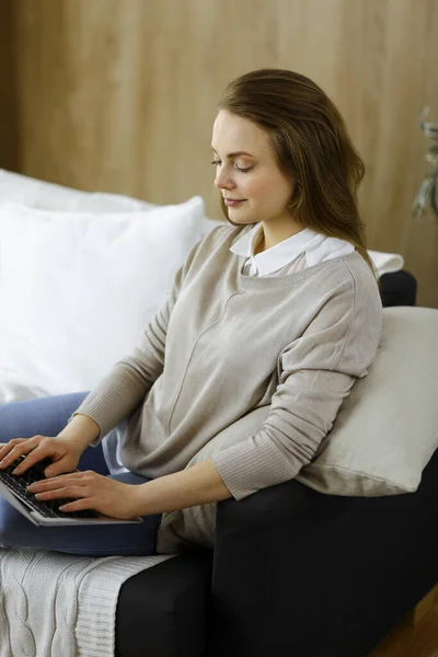 Bizneswoman pracująca na laptopie siedząc w domu podczas kwarantanny Covid-19 w przytulnym salonie. Pozostań w domu koncepcja podczas pandemii Coronavirus — Zdjęcie stockowe
