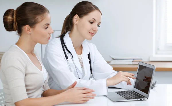 Az orvos és a beteg ül, és megbeszélik az egészségügyi vizsgálat eredményeit, miközben laptopot használnak. Egészségügy, orvostudomány és jó hírek — Stock Fotó