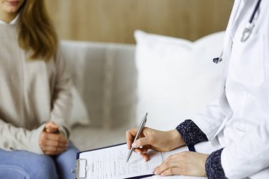 Bilinmeyen kadın doktor ve hasta içeride otururken sağlık muayenesini tartışıyorlar. Coronavirus salgını ve kendini izolasyon karantinası süresince evde kal