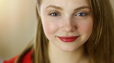 Zeki, kendinden emin, gülümseyen Avrupalı bir kadının resmi. Kollarını kavuşturmuş evde bekliyor.