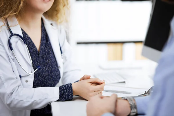Kadın doktor ve erkek hasta klinikte otururken sağlık muayenesini tartışıyorlar. Tıp konsepti — Stok fotoğraf